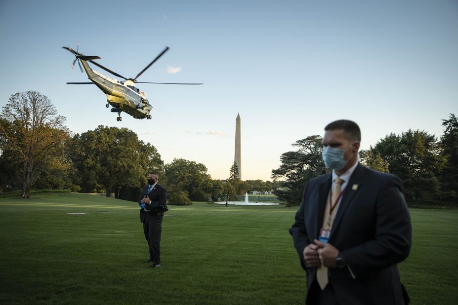 Secret Service agents stand on the South Lawn of the White House as the president is flown to Walter Reed Medical Center on October 2, 2020. He stayed at the hospital for three nights, receiving medical treatment after <a href=