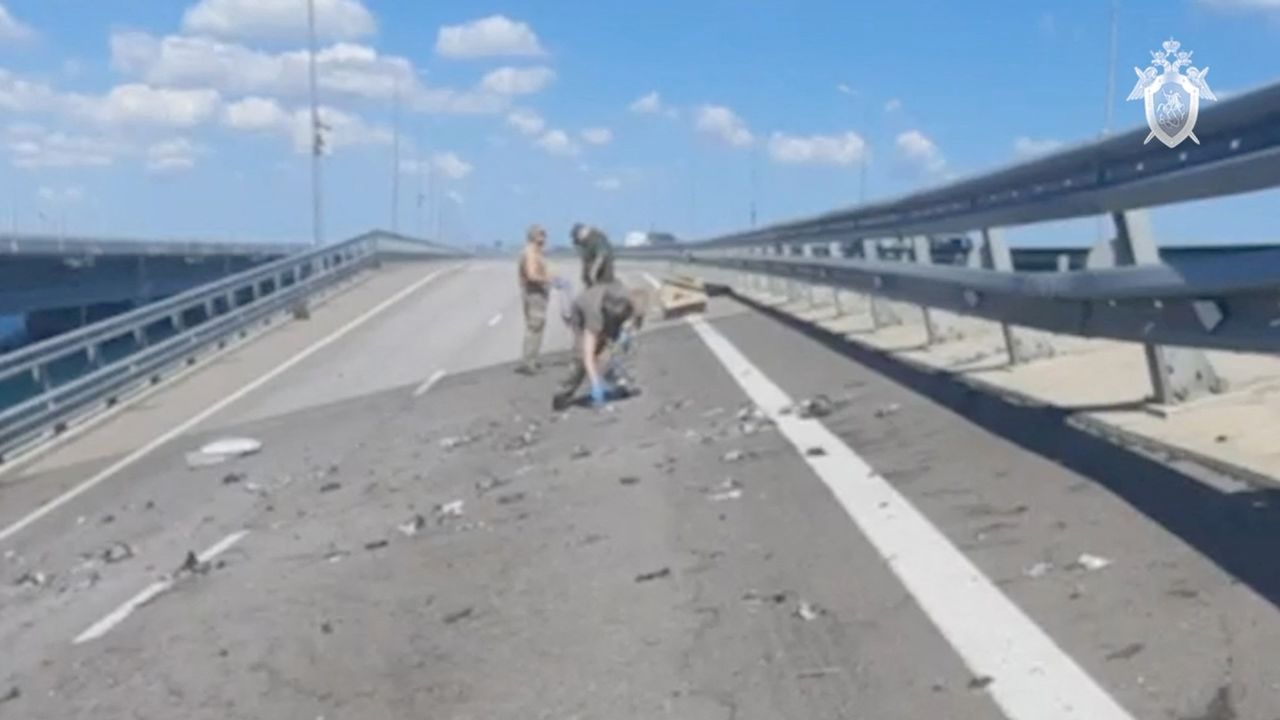 Russian investigators work at the accident scene on the section of a road sloping to one side following an alleged attack on the Crimea Bridge, that connects the Russian mainland with the Crimean peninsula across the Kerch Strait, in this still image taken from video released July 17, 2023.